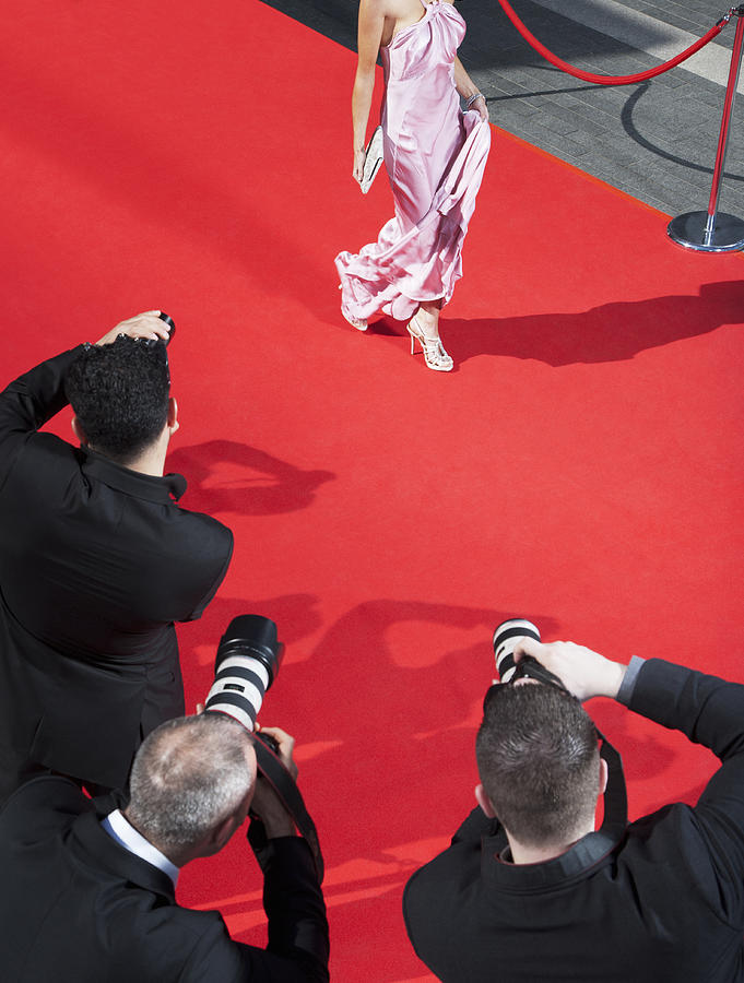 Celebrity walking for paparazzi on red carpet Photograph by Robert Daly