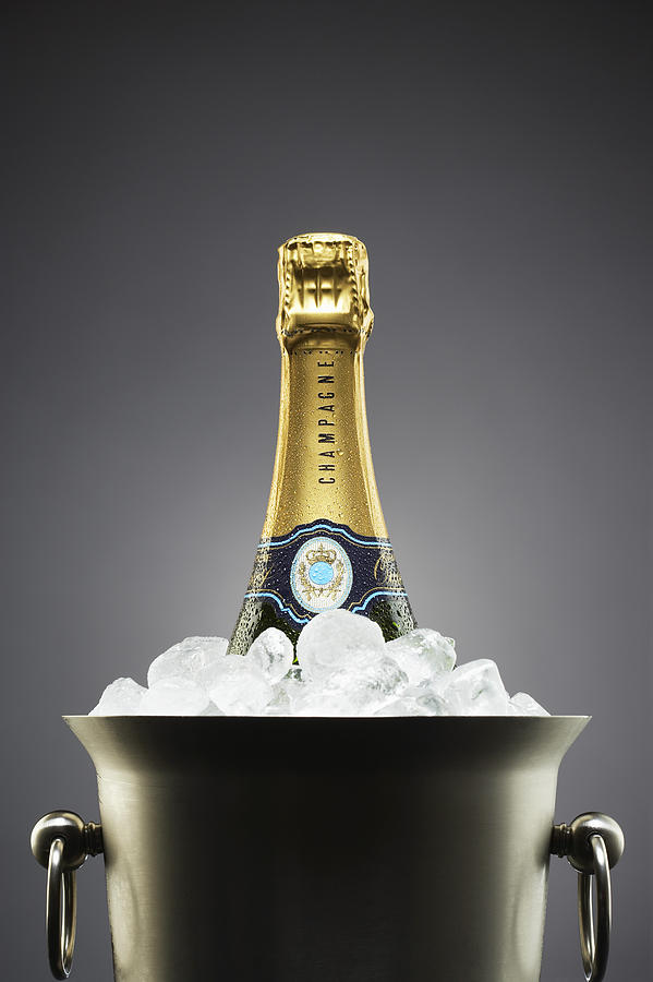 Champagne bottle in ice bucket Photograph by Moodboard