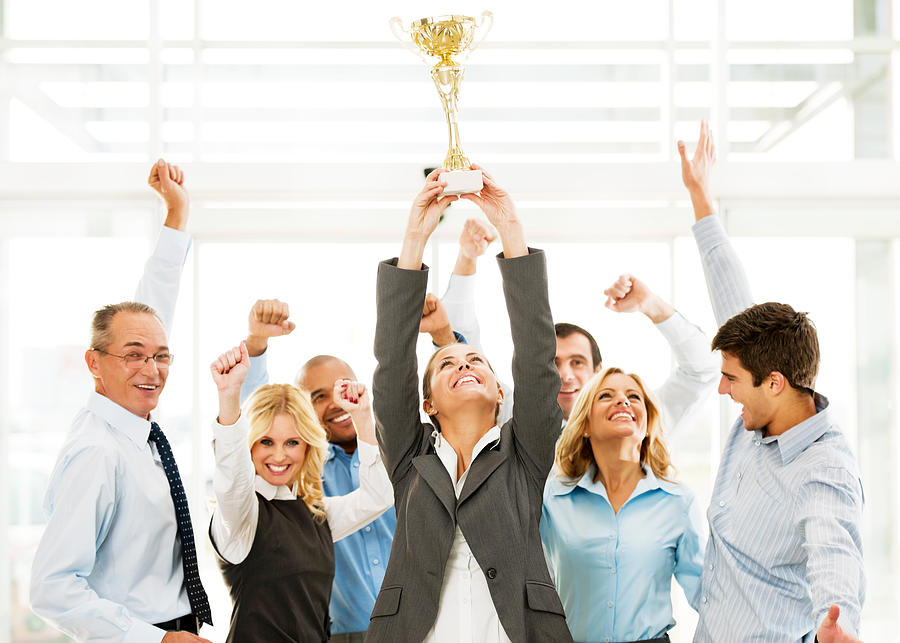 Cheerful group of businesspeople winning the cup with hands up. Photograph by Skynesher