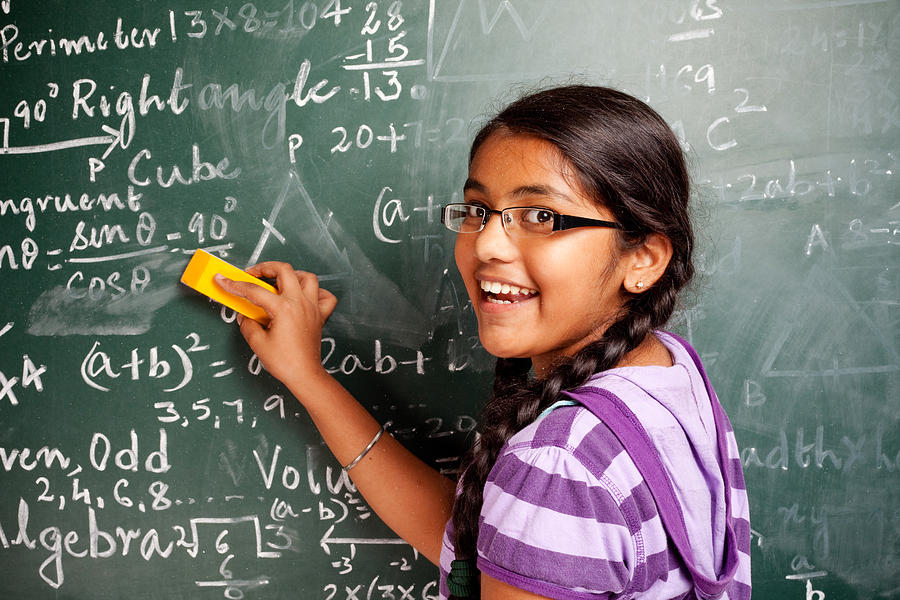 Cheerful Indian Girl Student Erasing Mathematics Problems from Greenboard Blackboard Photograph by VikramRaghuvanshi