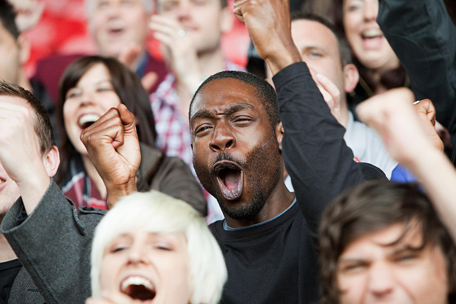 Cheering man at football match Photograph by Image Source