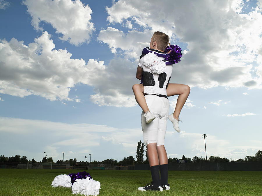 Cheerleader and Footballer Hugging Photograph by Tony Anderson