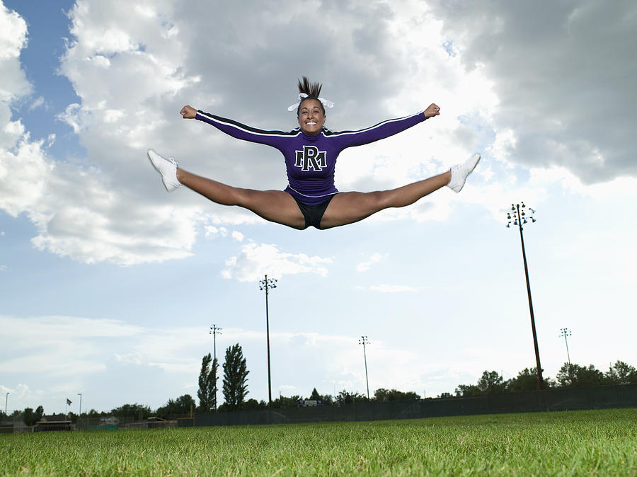 Cheerleader doing Toe Touch Jump Photograph by Tony Anderson