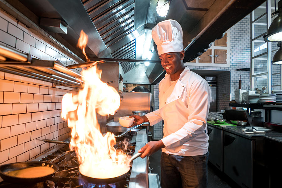 Chef flaming food at a restaurant Photograph by Andresr