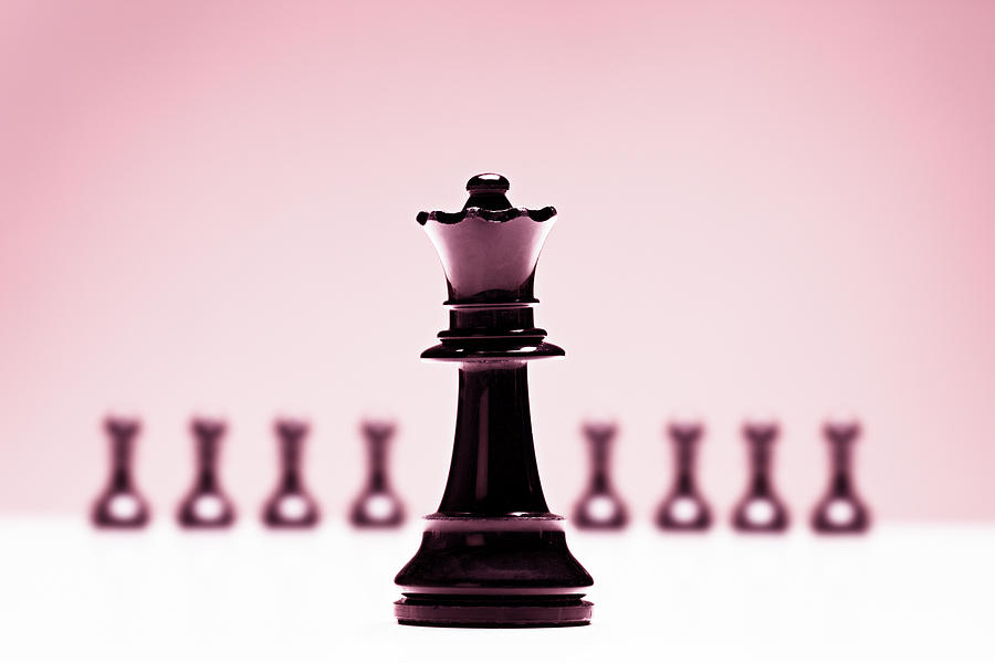 Chess queen in front of pawns on pink background Photograph by RapidEye