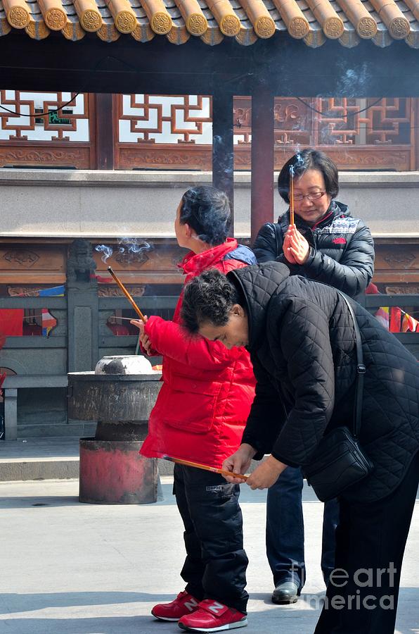 Child mother and grandmother burn incense at temple Shanghai China Photograph by Imran Ahmed