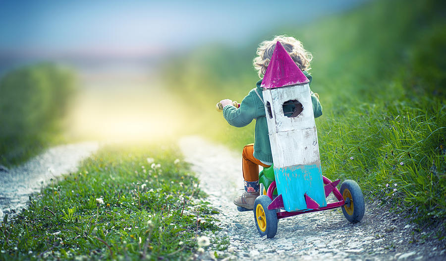 Child on Tricycle Carrying a Toy Space Rocket Photograph by Loops7