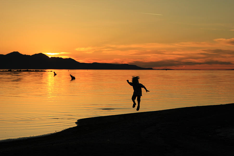 Sunset Photograph - Child playing while the sun sets. by Wasatch Light