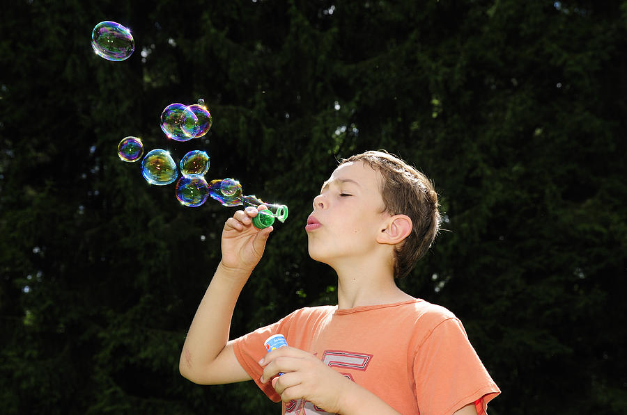 Child playing with bubbles Photograph by Matthias Hauser