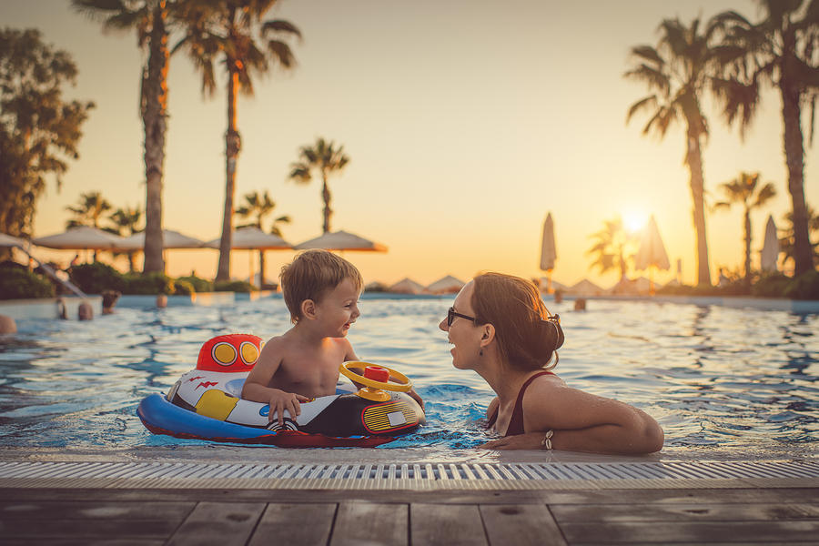 Child with mother in swimming pool, holiday resort Photograph by ArtMarie