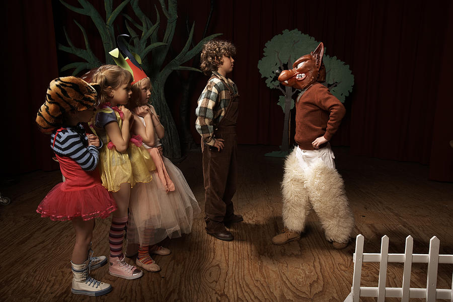 Children (5-12) acting on stage, one boy confronting bad wolf Photograph by Adam Taylor