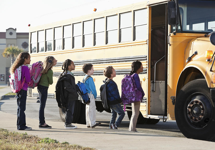 Children boarding school bus Photograph by Kali9