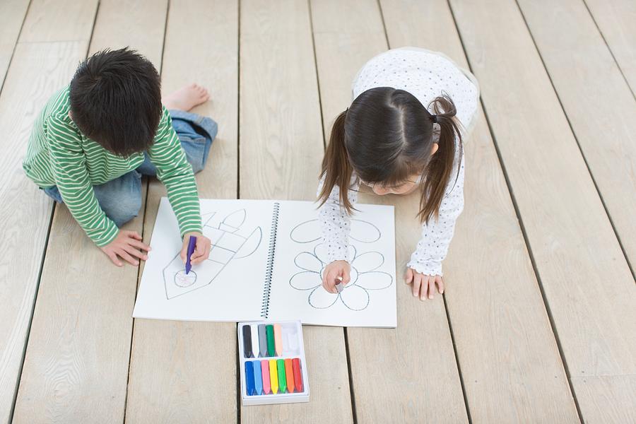 Children drawing with crayons Photograph by Image Source