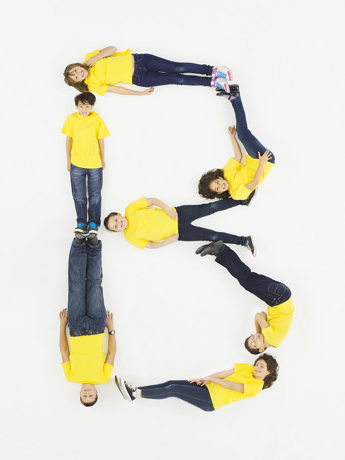 Children laying in letter B formation Photograph by Compassionate Eye Foundation/Jasper White