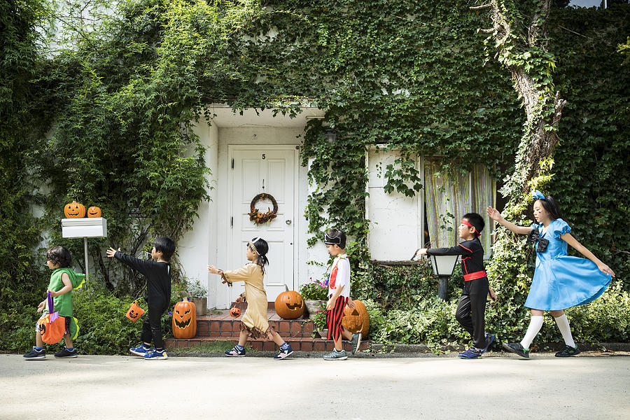 Children marching in front of the house wearing costumes. Photograph by Kokouu