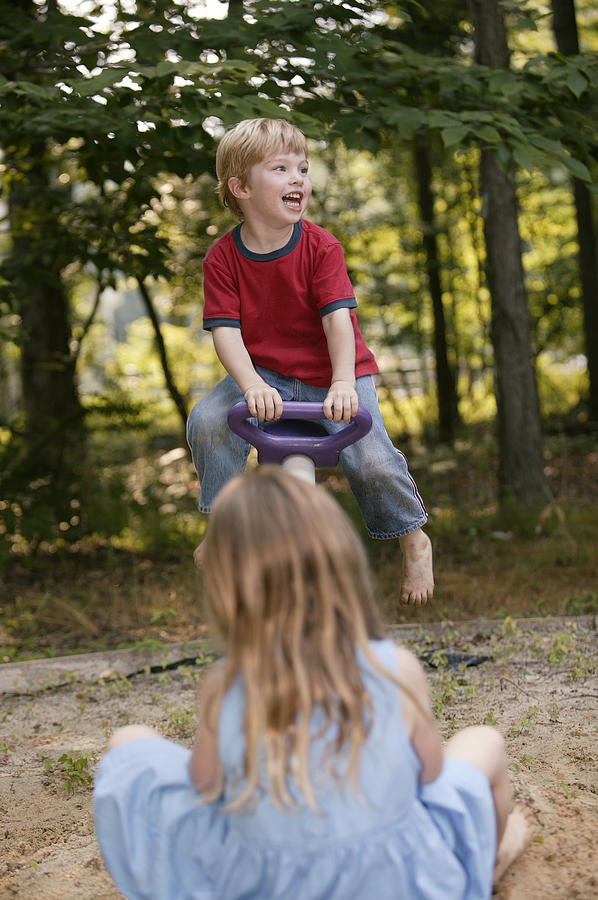 Children playing on a seesaw Photograph by Comstock