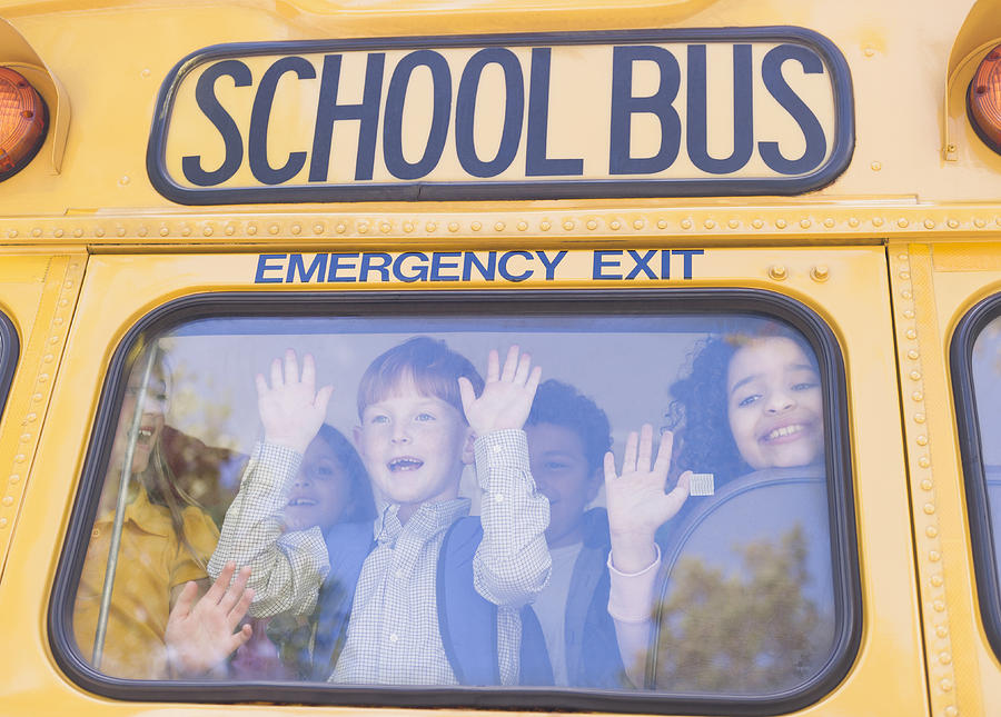 Children riding school bus Photograph by Blend Images - JGI/Jamie Grill