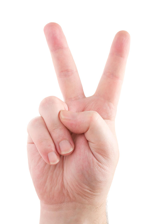Childs hand making peace sign on white background Photograph by JoKMedia