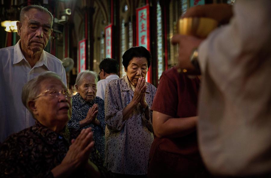 Chinese Catholics Worship As Pope Sends Photograph by Kevin Frayer