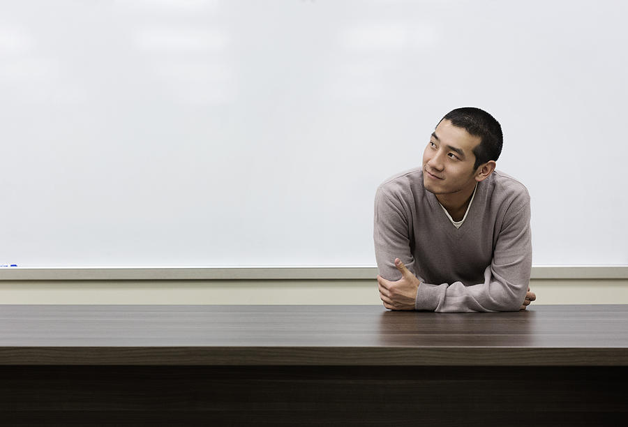 Chinese student standing at whiteboard in classroom Photograph by Hill Street Studios