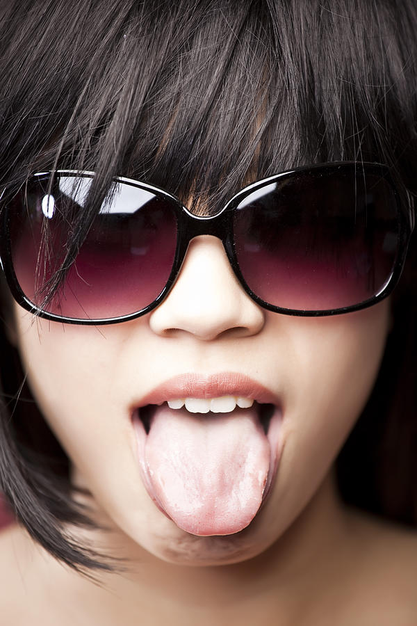 Chinese woman wearing sunglasses and tongue out Photograph by Take A Pix Media