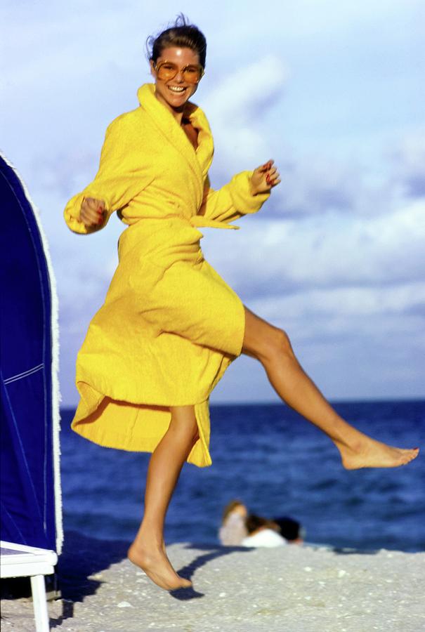 Christie Brinkley Wearing A Yellow Robe Photograph by Arthur Elgort
