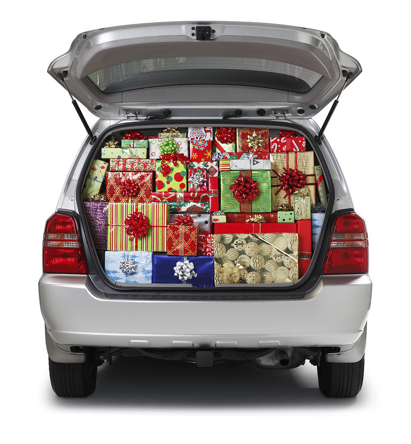 Christmas presents stuffed into SUV isolated on white background Photograph by Dny59