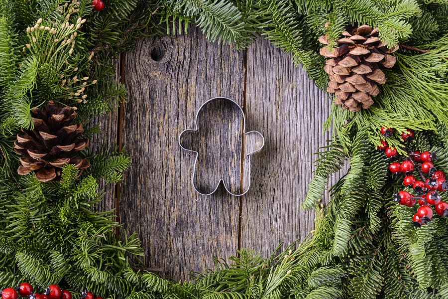Christmas Photograph - Christmas Wreath with Gingerman Cookie in the Middle of Wood Bac by Brandon Bourdages
