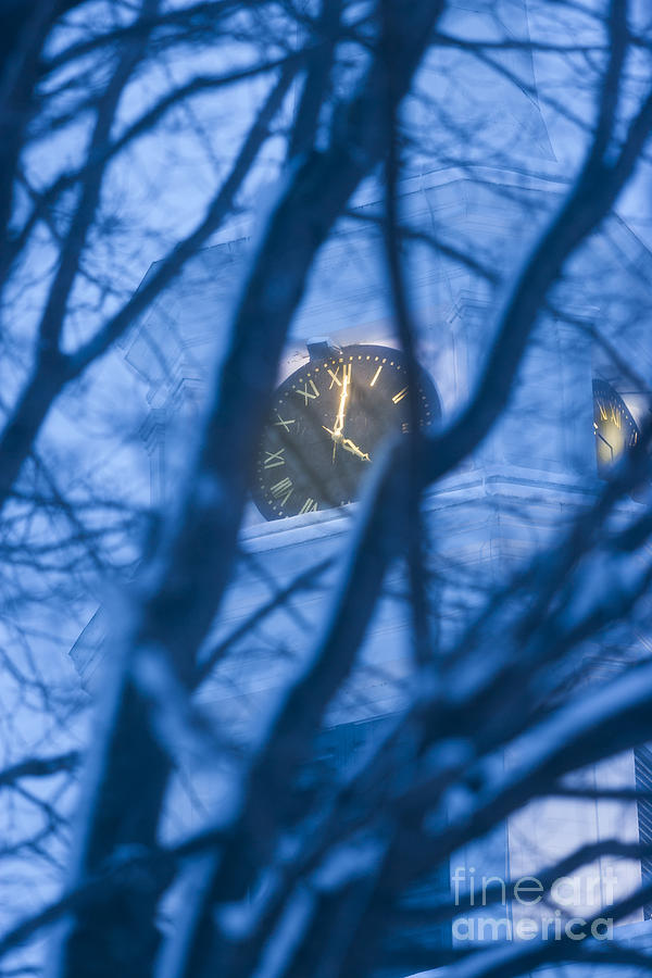 Church clock through trees at dusk. Photograph by Don Landwehrle