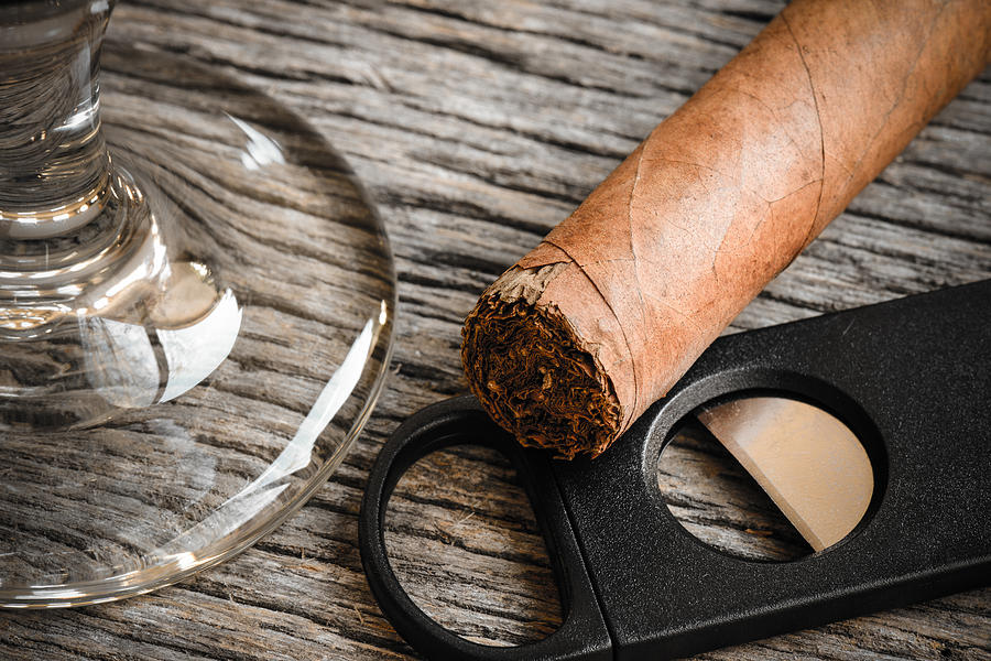 Cigar and Cutter with Glass of Brandy or Whiskey on Wooden Backg Photograph by Brandon Bourdages