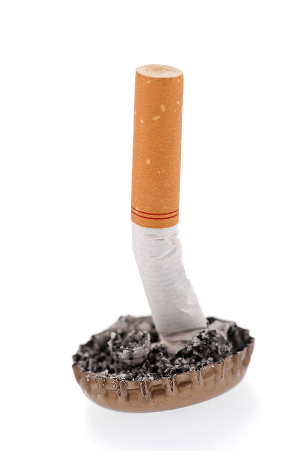 Cigarette butt and ash in a bottle cap Photograph by Marek Poplawski