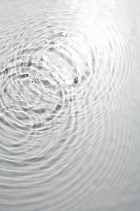 Circle ripples on water surface Photograph by Hiroshi Watanabe