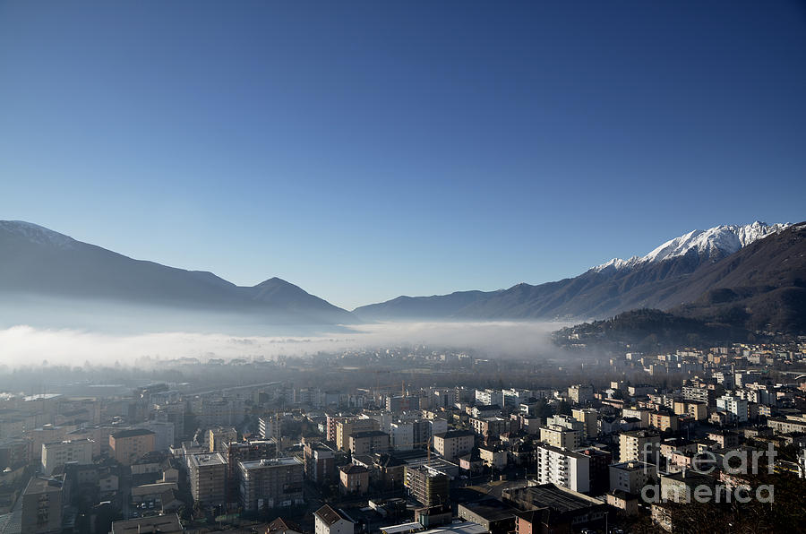 City with snow-capped mountain Photograph by Mats Silvan