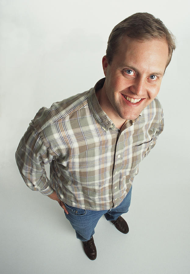 Clean-cut Young Adult Male Caucasian Wearing A Plaid Shirt Stands Casually Looking Up At The Camera And Smiling Photograph by Photodisc