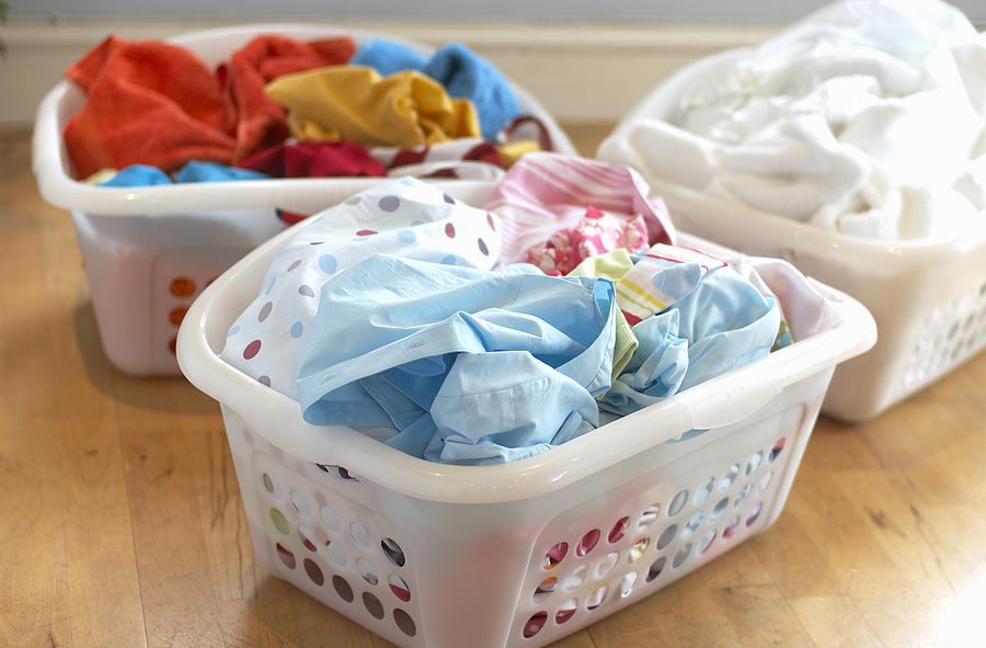 Clean washing in three plastic laundry baskets Photograph by Howard Shooter