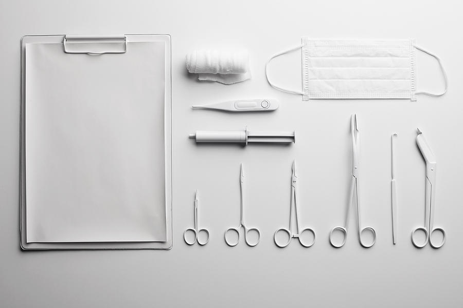 Clipboard, various medical scissors and instruments painted white and arranged neatly Photograph by Larry Washburn
