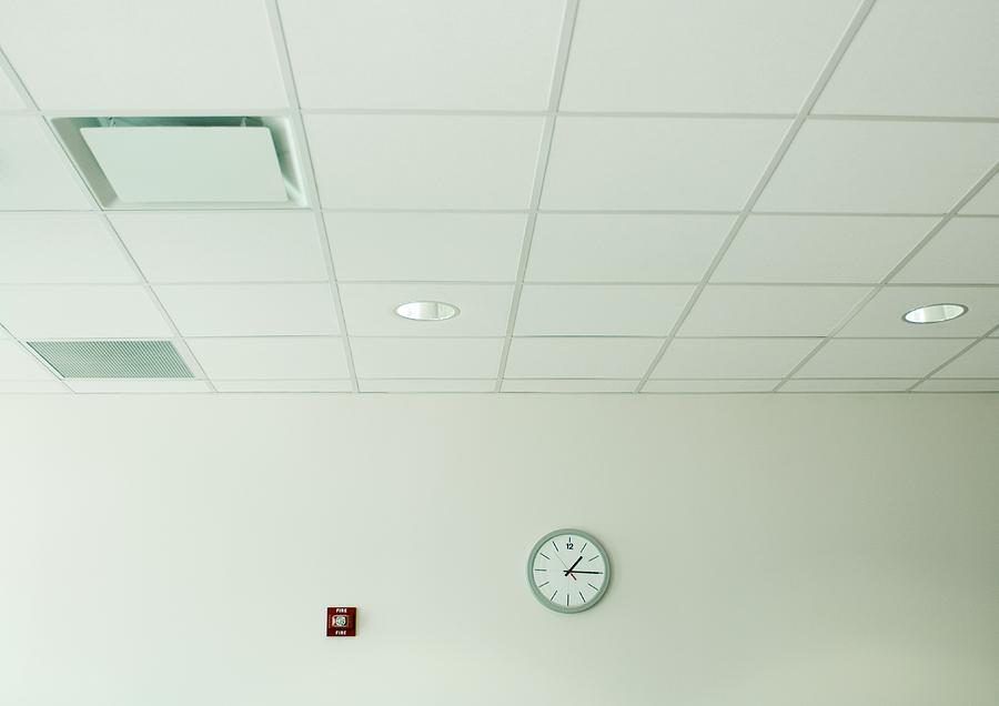 Clock on wall in office space Photograph by Matthieu Spohn
