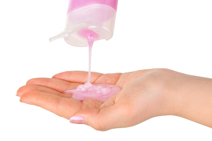 Close up image of woman pouring pink shampoo onto her hand  Photograph by TPopova
