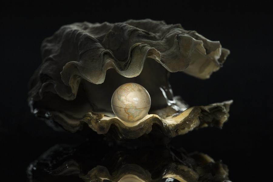 Close-up of a globe in an oyster Photograph by Rubberball/Mike Kemp