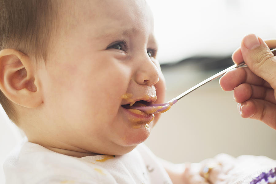 Close-up of baby girl (12-17 months) being spoon fed, Jersey City, New Jersey, USA Photograph by Tetra Images