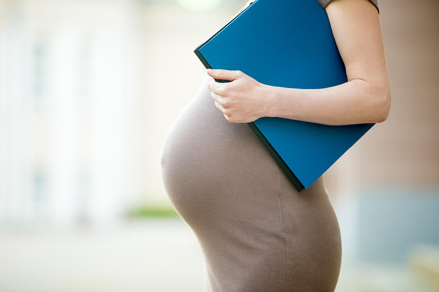 Close-up of belly of pregnant woman office worker Photograph by Fizkes