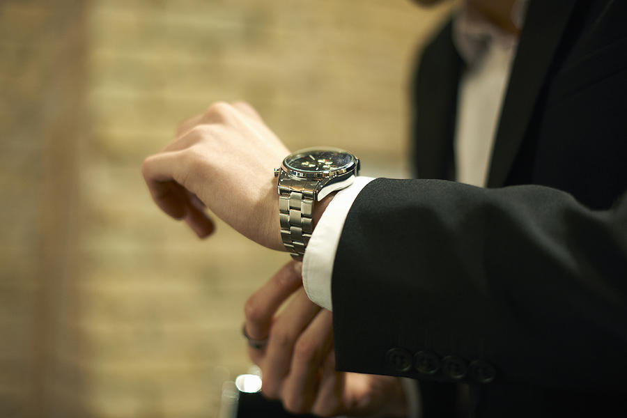 Close up of businessman fastening wristwatch Photograph by Peter Muller