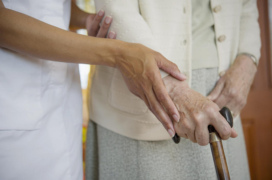 Close up of caretaker helping older woman walk Photograph by Jacobs Stock Photography Ltd