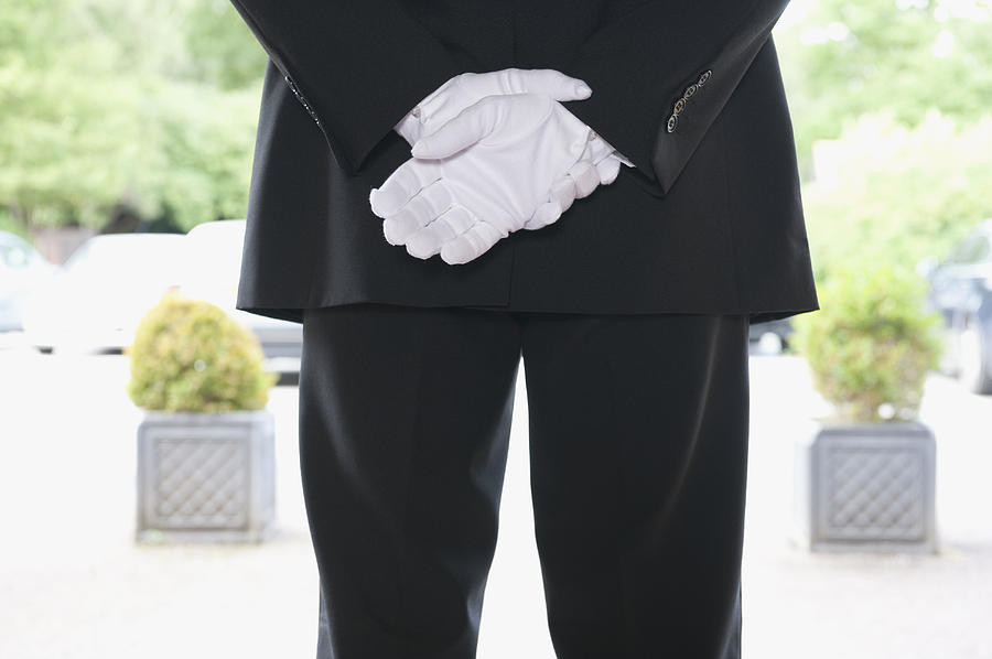 Close up of Caucasian butler waiting at hotel entrance Photograph by Jacobs Stock Photography Ltd