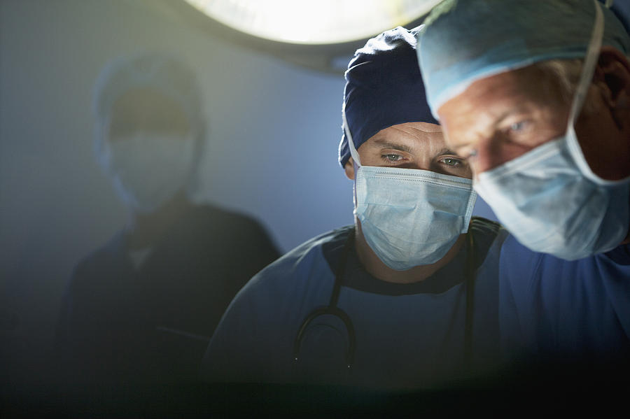 Close up of focused surgeons working in operating room Photograph by Sam Edwards