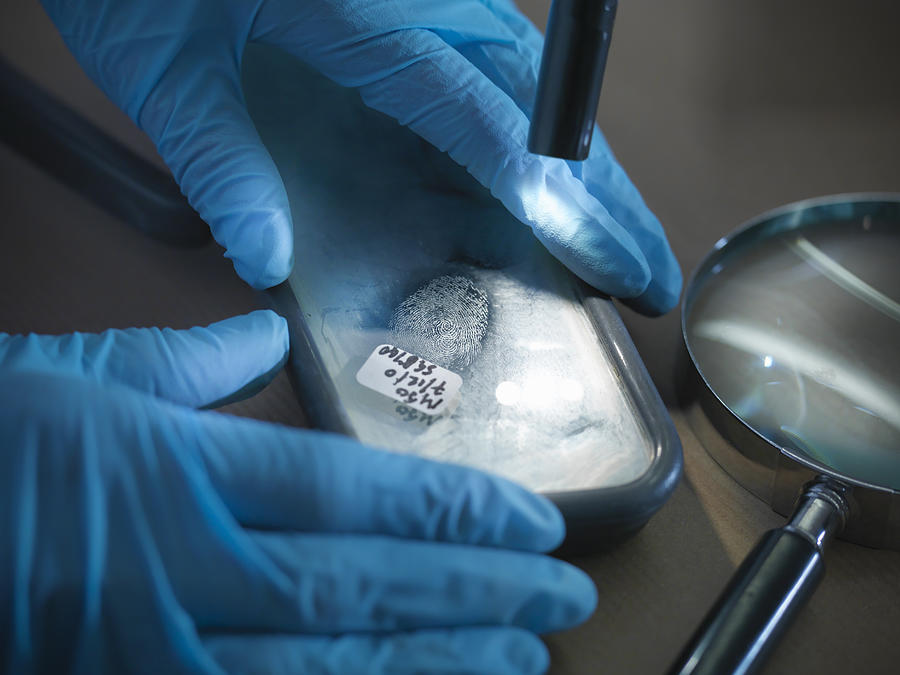 Close up of forensic scientist examining finger print in laboratory Photograph by Monty Rakusen