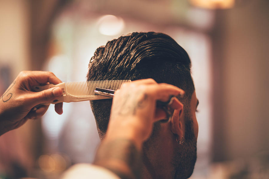 Close-up of hairstylists hands cutting strand of mans hair Photograph by Wundervisuals