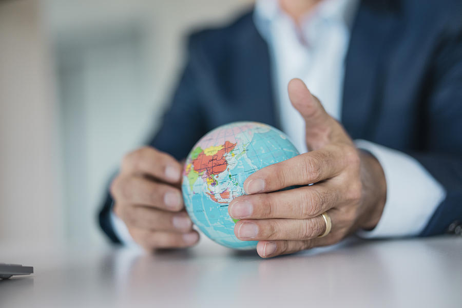 Close-up of hands of businessman holding globe Photograph by Westend61