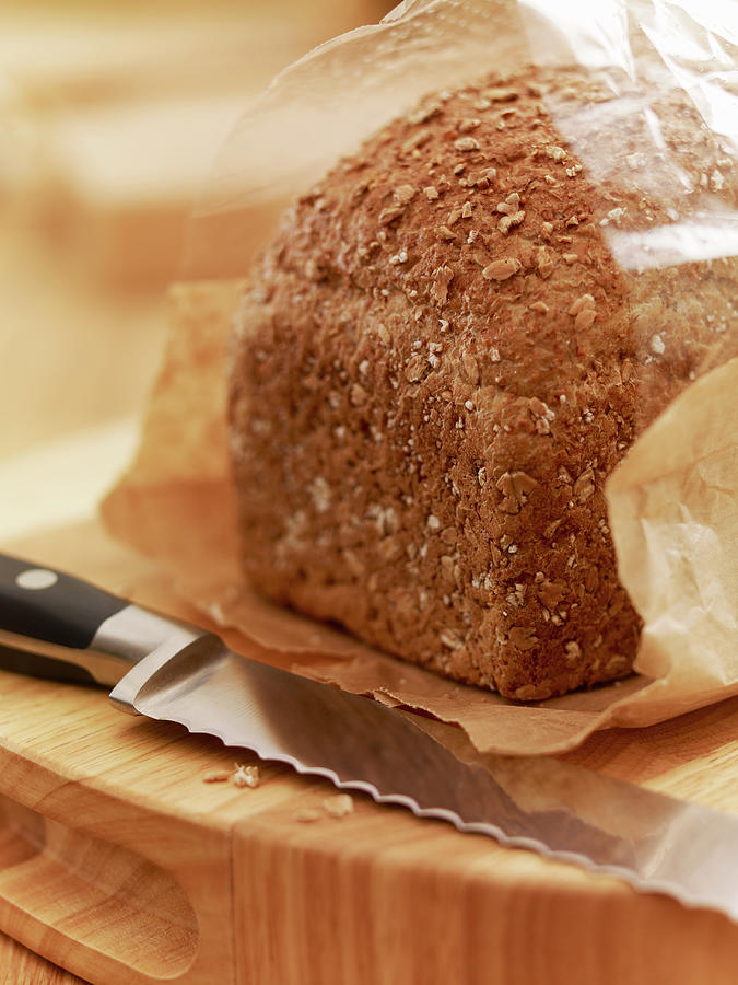 Close Up Of Knife And Loaf Of Bread In Photograph by Adam Gault
