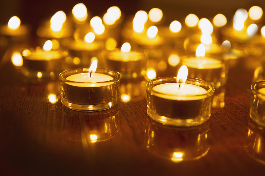 Close up of lit tea light candles on wooden table Photograph by Jacobs Stock Photography Ltd